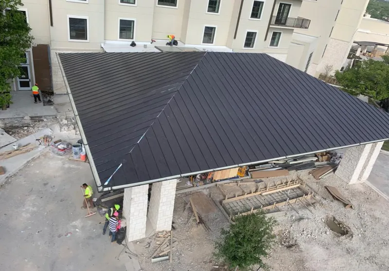 Metal roofing installation team working on a commercial building in Hilo